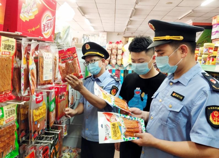 图为6月10日该局执法人员正在银坑镇一学校周边食品店检查辣条质量。