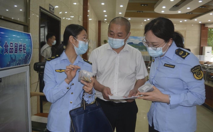 图为执法人员在食品检查留样情况。