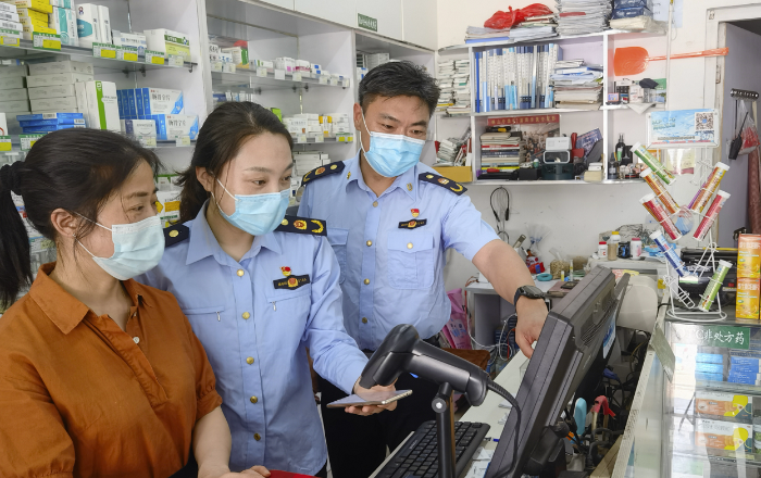 图为江都市场监管局执法人员核查“四类药品”登记销售记录。