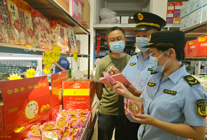 图为8月15日，该局执法人员在一家商超检查月饼质量。