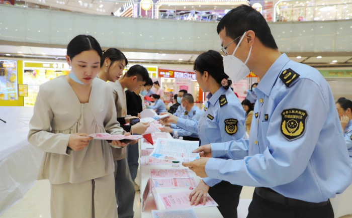 图为该局执法人员在活动现场向群众发放化妆品科普宣传资料。