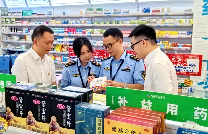 图为涪陵区市场监管局马鞍街道执法人员在一家药店检查药品有效期。（文光辉 摄）