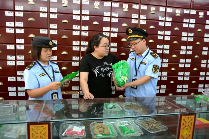 图为10月9日，该局青羊镇市场监管所执法人员在一家药店检查中药饮片是否变质。（文光辉 摄）